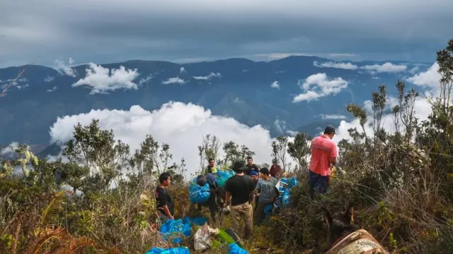 Expedición cargando material sobre una cresta, ruta de la Quebrada de Yanatile