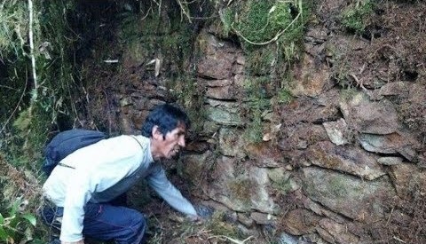 Guía examinando un muro del sitio piramidal de Lacco Mapacho